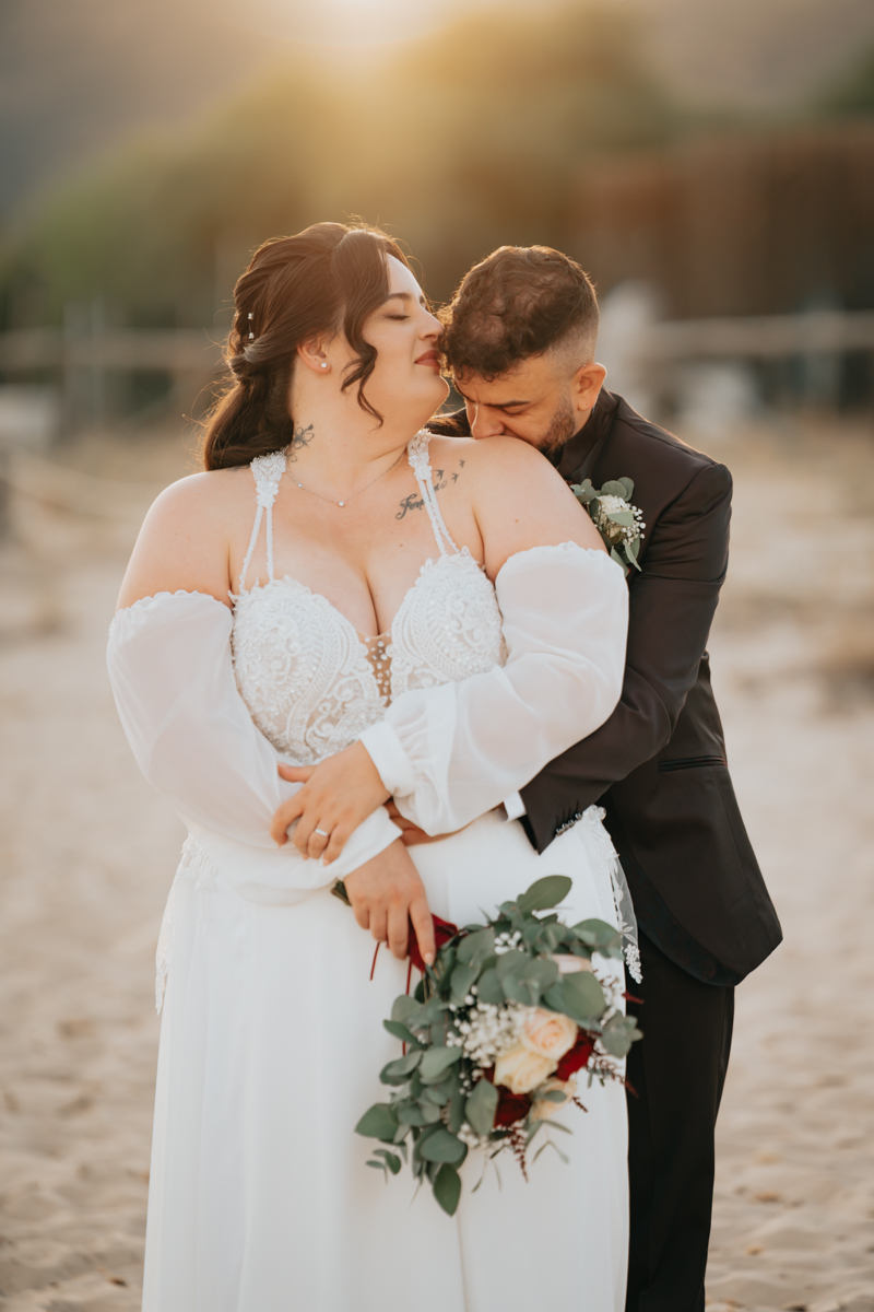 sposi durante un momento spontaneo del matrimonio in spiaggia a Pula