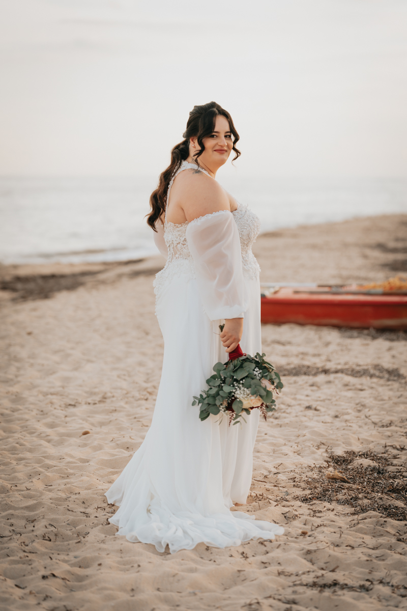 sposi durante un momento spontaneo del matrimonio in spiaggia a Pula