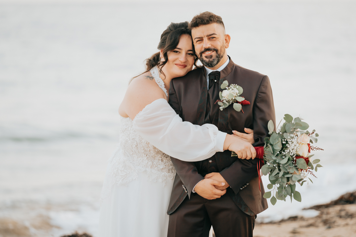 sposi durante un momento spontaneo del matrimonio in spiaggia a Pula
