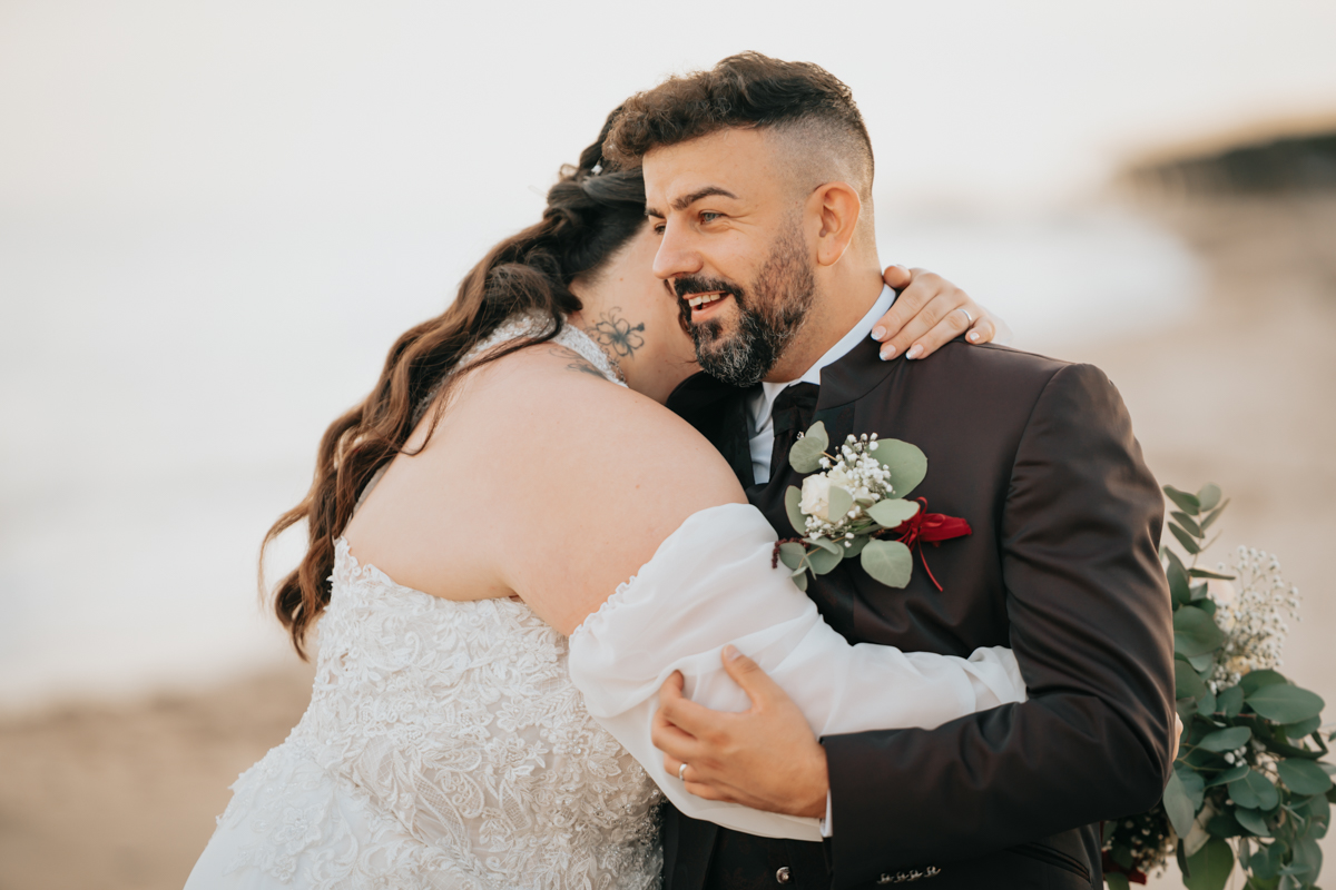 sposi durante un momento spontaneo del matrimonio in spiaggia a Pula