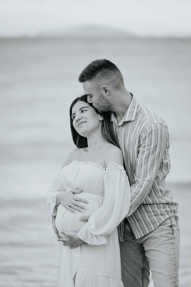 Servizio fotografico gravidanza a Mari Pintau con cielo nuvoloso e luce morbida sul mare