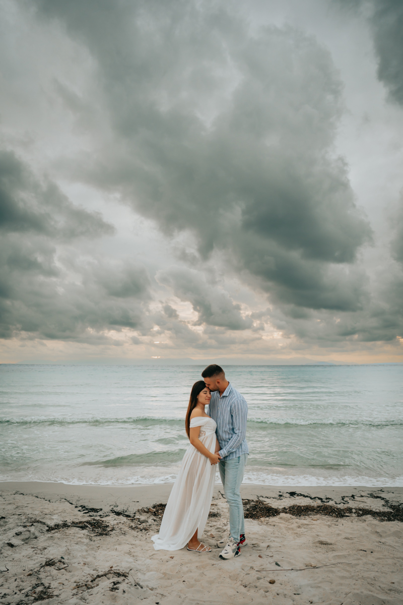 Servizio fotografico gravidanza a Mari Pintau con cielo nuvoloso e luce morbida sul mare